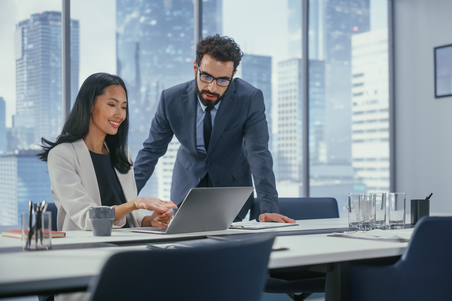 2 people working together in a high rise looking at a computer