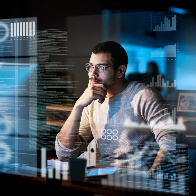 Man looking at computer with graphics and tech overlay